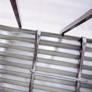 Detail of Bright Idea Egress clear well cover with clips designed to precisely fit our egress window wells